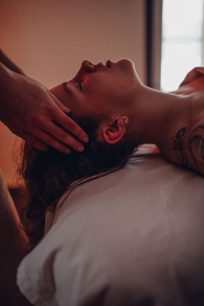 massage bodywork session with hands on a womans face
